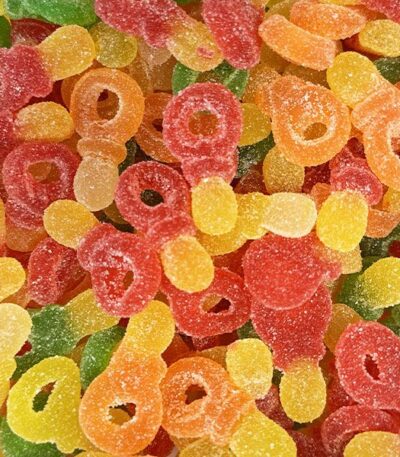 Mélange de bonbons gélifiés en forme de tétines multicolores (rouge, jaune, orange, vert), recouverts d'un voile de sucre acidulé, certifiés Halal par Bebeto.