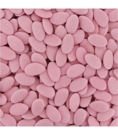 Plan serré sur des dragées fluides au chocolat noir 71% de cacao avec un enrobage de sucre fin rose poudré mat.