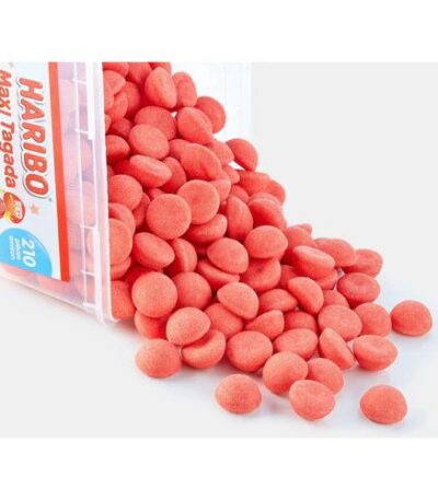 Boîte de Haribo Maxi Tagada renversée laissant apparaître une multitude de fraises rouges guimauve sucrées sur fond blanc.