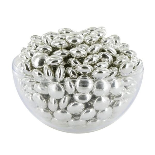 Coupe en verre remplie de petites dragées rondes au chocolat avec un enrobage argenté brillant et métallisé.